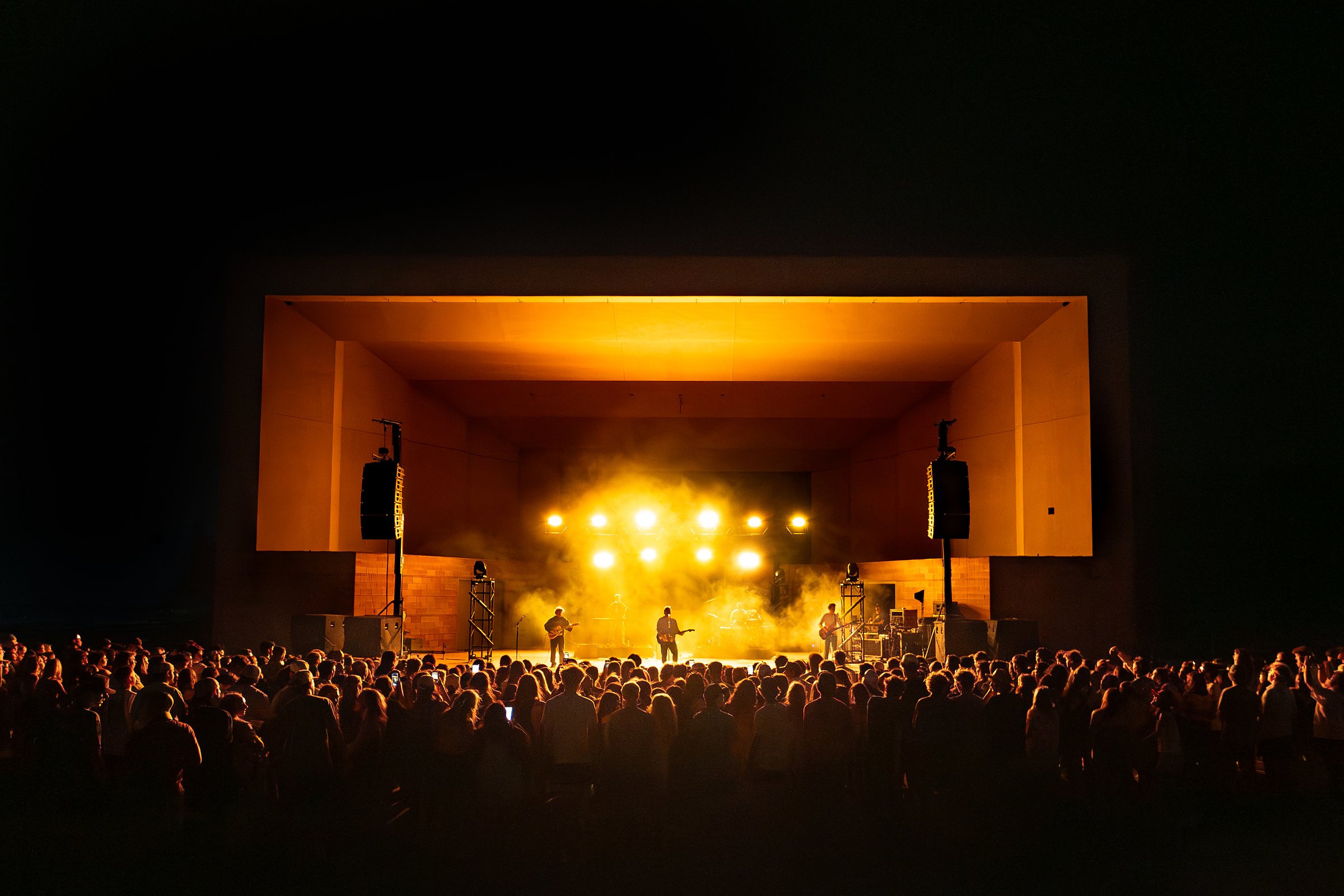 Main stage lit at night with the crowd in front